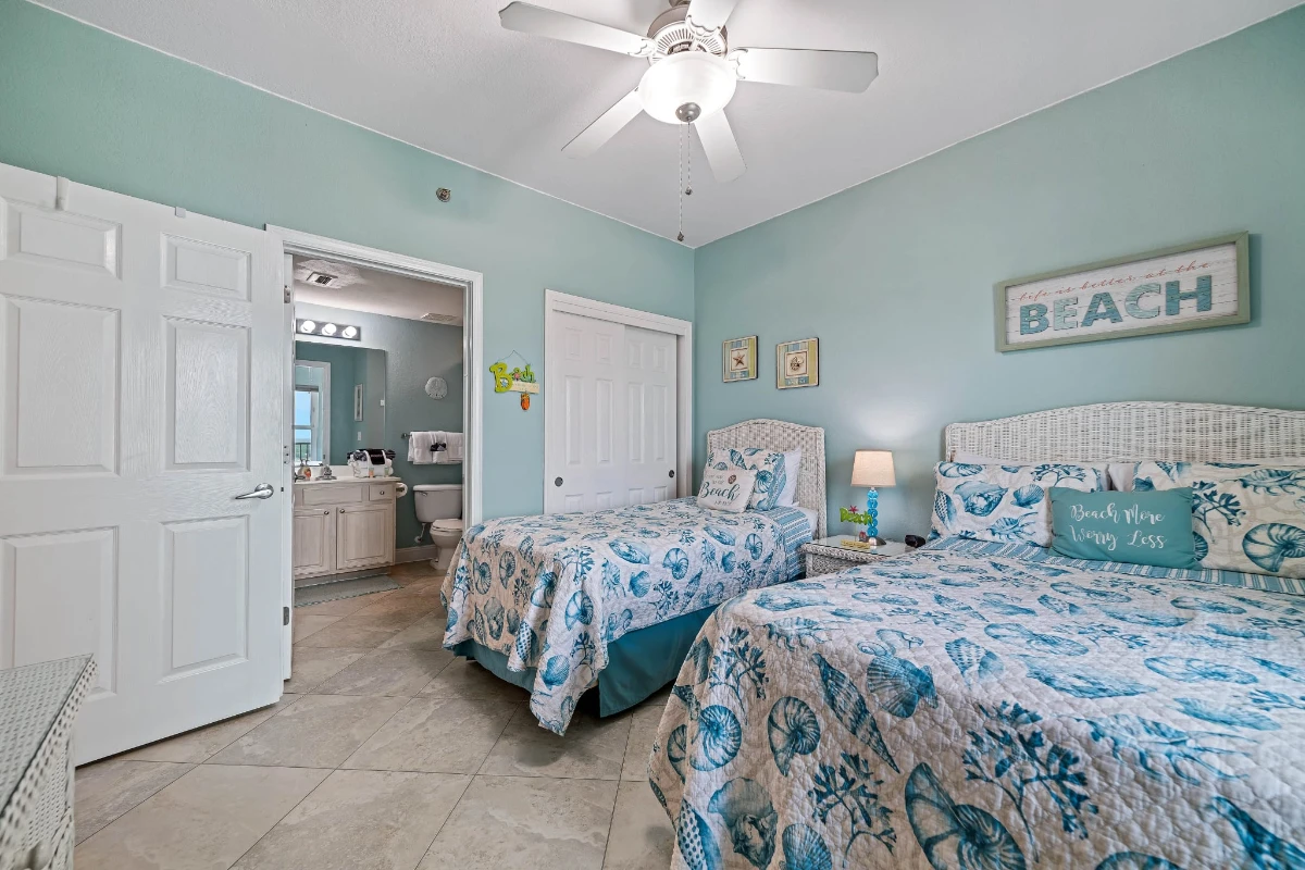 Coastal-themed bedroom with two beds and beach decor at Salty Air Retreat